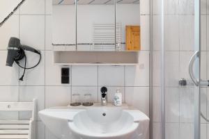 a white bathroom with a sink and a shower at Ferienwohnung Brasil, 76 Qm in Schonach +32 photos