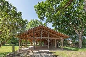 a wooden pavilion in a park with trees at Villa L'Andélu - Conciergerieland in Saint-Michel-Escalus