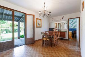 a kitchen and dining room with a table and chairs at Villa L'Andélu - Conciergerieland in Saint-Michel-Escalus