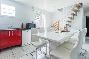 a kitchen with a white counter and a white table and chairs at Villa 4 Saisons, piscine chauffée in Vieux-Boucau-les-Bains