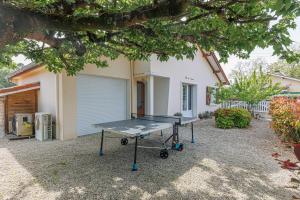 a ping pong table in front of a house at Villa 4 Saisons, piscine chauffée in Vieux-Boucau-les-Bains