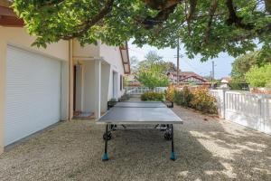 a ping pong table in front of a house at Villa 4 Saisons, piscine chauffée in Vieux-Boucau-les-Bains