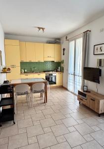 a kitchen with a table and chairs in a room at Appartamento Nuvola Bianca 1 in Cesenatico