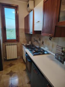 a kitchen with a stove top oven next to a window at Benvenuti a casa in Certaldo