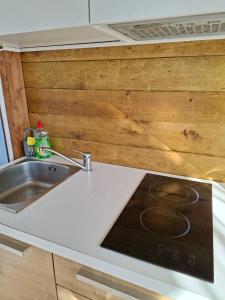 a kitchen counter with a sink and a stove at Mobile home Magdalena in Pirovac +25 photos
