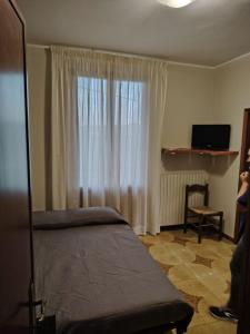 a bedroom with a bed and a window and a chair at Benvenuti a casa in Certaldo