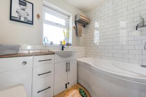 a white bathroom with a tub and a sink at Panoramic Sunset Views - Free Parking & Sleeps 5 in Heywood +16 photos