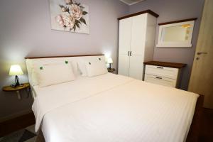 a bedroom with a large white bed with two pillows at BellaVita Apartman in Vrnjačka Banja