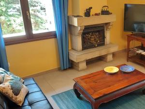 a living room with a fireplace and a coffee table at La Casa de la Huerta in Vinuesa