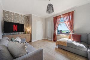a living room with a couch and a tv at Panoramic Sunset Views - Free Parking & Sleeps 5 in Heywood