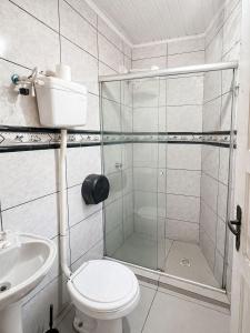 a bathroom with a shower and a toilet and a sink at Hostel & Coffe Bahia in Porto Alegre +17 photos