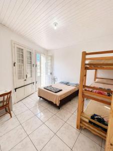 a bedroom with a bed and two bunk beds at Hostel & Coffe Bahia in Porto Alegre