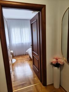 a hallway with a door and a vase with flowers at 2Hearts Apartment - Medjugorje in Međugorje +26 photos