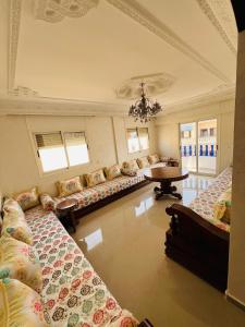 a large room with couches and a table and windows at Chez Yamaa in Oualidia