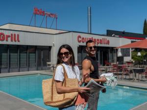a man and a woman standing in front of a pool at ibis Orange Centre Echangeur A7 A9 in Orange