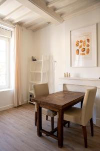 a dining room with a wooden table and chairs at Studio Saint-Patrice - centre historique Bayeux in Bayeux +9 photos