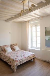 a bedroom with a bed in a room with a window at Studio Saint-Patrice - centre historique Bayeux in Bayeux