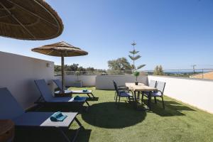 a patio with a table and chairs and an umbrella at Royal Touch Suite in Loutra