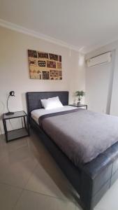 a bedroom with a large bed and a side table at Sea View Haven in Accra
