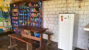 a table and a refrigerator in a room at Casa rosa in Maracanã