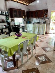 a kitchen with a table with a green table cloth at Casa rosa in Maracanã