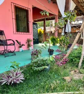 a pink house with plants in the yard at Casa rosa in Maracanã +36 photos