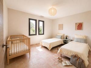 a bedroom with two beds and a crib in it at Villa familiale avec piscine hyper centre in Valras-Plage +52 photos