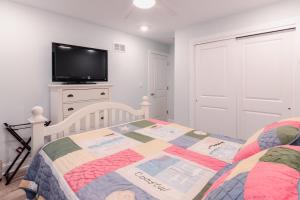 a bedroom with a bed and a flat screen tv at The Royal Treat in Lavallette