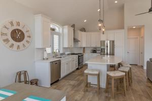 a kitchen with white cabinets and a large clock on the wall at The Royal Treat in Lavallette