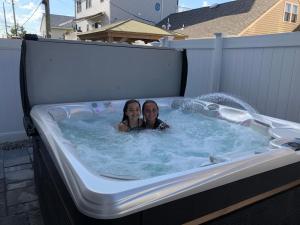 two girls are sitting in a hot tub at The Royal Treat in Lavallette +1 photo