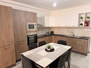 a kitchen with a table and a kitchen with white cabinets at 11 Rose in Sannat