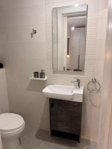 a bathroom with a sink and a toilet and a mirror at 11 Rose in Sannat +16 photos