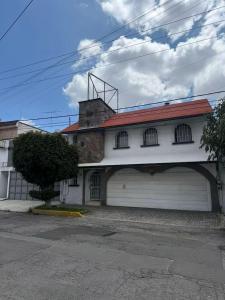 a white house with a garage with a red roof at Comodo Estudio 8 in El Gallinero