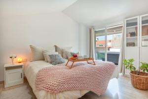 a bedroom with a bed with a table on it at Duplex Beach Masnou in El Masnou