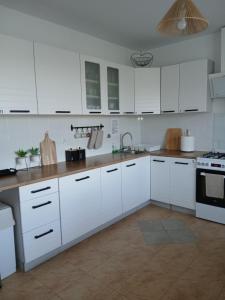 a white kitchen with white cabinets and a sink at Noclegi U Janusza - Bieszczady in Polańczyk