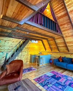 a living room with a blue couch and a wooden ceiling at Vice Suit Bungalov in Sapanca +3 photos
