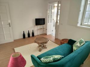 a living room with a blue couch and a table at 4-As Andar-Moradia Muralhas in Guimarães