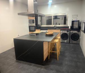 a kitchen with a black island in a kitchen at Villa La Roca con casita independiente in Guadarrama +47 photos