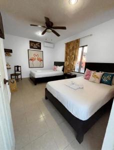 a bedroom with two beds and a ceiling fan at La placita hotel in Río Lagartos