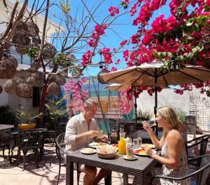 a man and woman sitting at a table eating food at La placita hotel in Río Lagartos