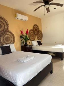 a hotel room with two beds and a fan at La placita hotel in Río Lagartos +9 photos