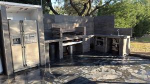 a stainless steel kitchen with a stove and a refrigerator at Villa La Roca con casita independiente in Guadarrama