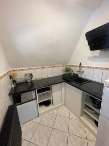 a small kitchen with a sink and a counter at Leśny Dworek Marianny 4 osobowy in Miedzygorze +6 photos