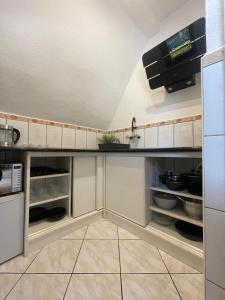 a kitchen with white cabinets and a counter top at Leśny Dworek Marianny 4 osobowy in Miedzygorze