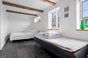 two beds in a room with two windows at 20229-Samso-Byvejen-20 in Hårdmark