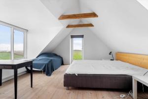 a bedroom with a bed and a desk and a window at 20622-Samso-Skolebakkevej-38 in Brundby