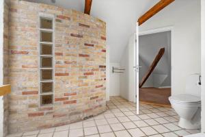 a brick wall in a bathroom with a toilet at 20622-Samso-Skolebakkevej-38 in Brundby +14 photos