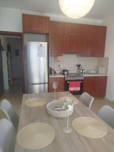a kitchen with a table with chairs and a refrigerator at Paulina's House in Politika