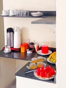 a table with plates of fruit and drinks on it at Hospedaria Barão in Campinas