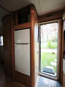a door to a kitchen with a refrigerator and a window at Cara Cabin Self Catering Tiny Home in Wexford